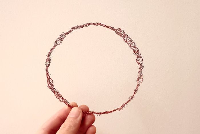 A bracelet made of red wire. 